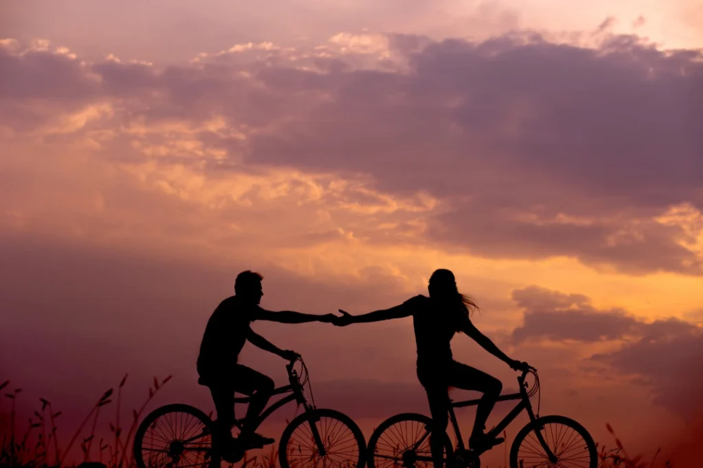Silhouette of a couple riding bikes at sunset