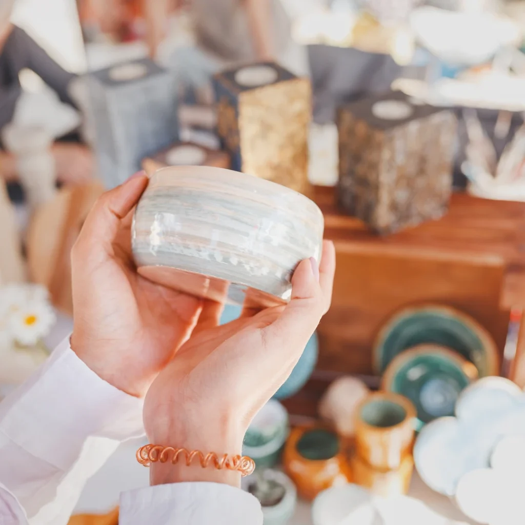 Woman holding piece of pottery at craft market
